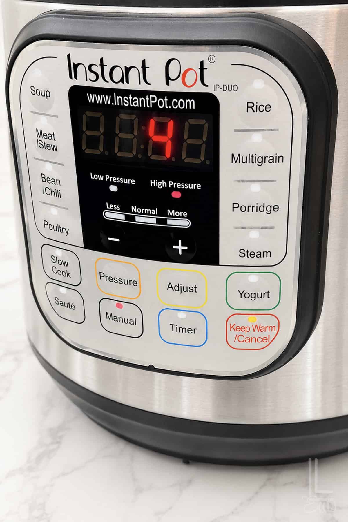 Instant Pot control panel displaying pressure level and settings for cooking.