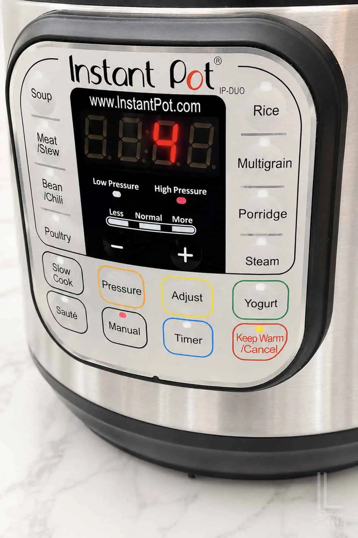 Instant Pot control panel displaying pressure level and settings for cooking.