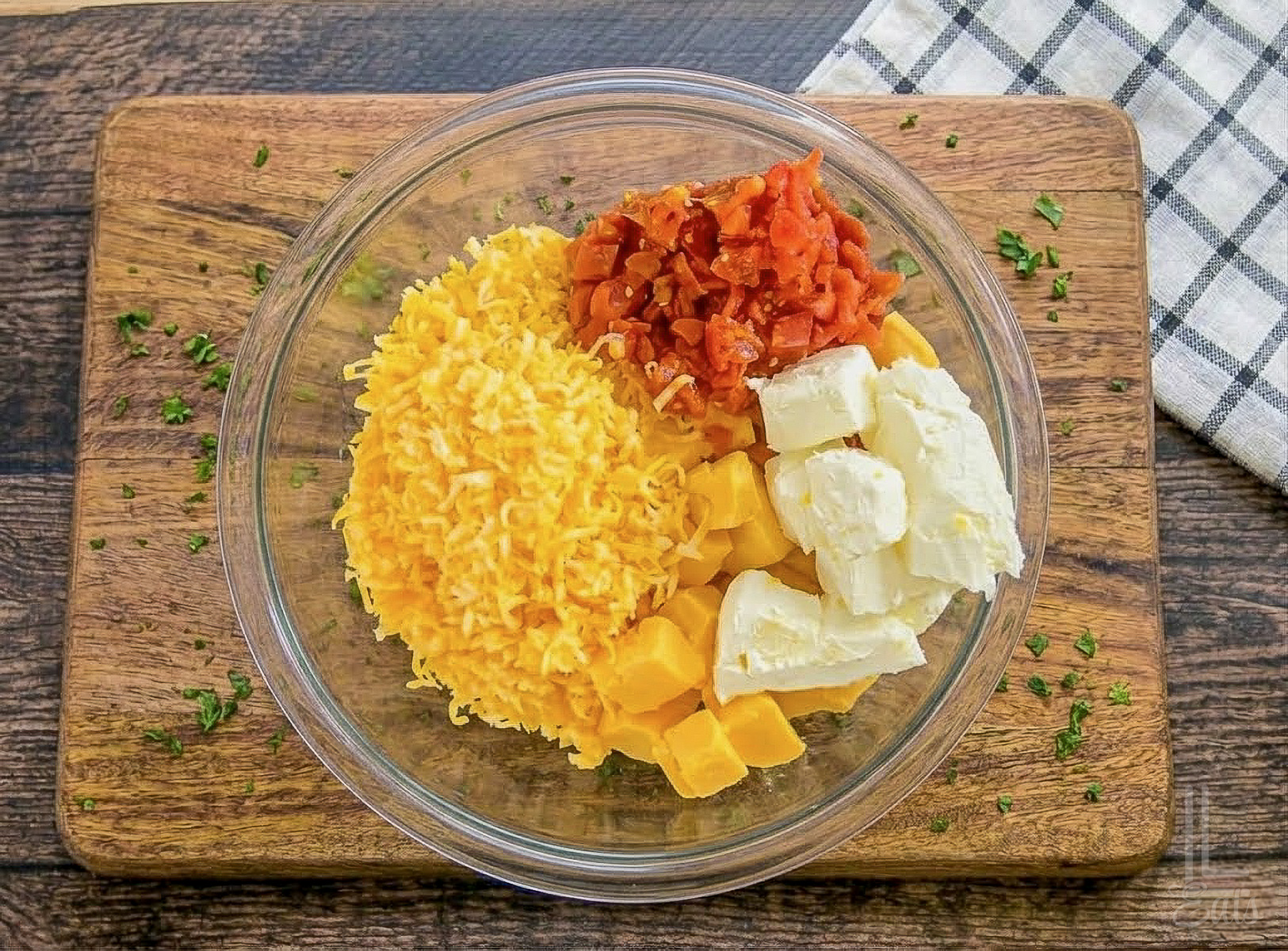 velveeta, cream cheese, rotel, and shredded colby jack cheese in a bowl.