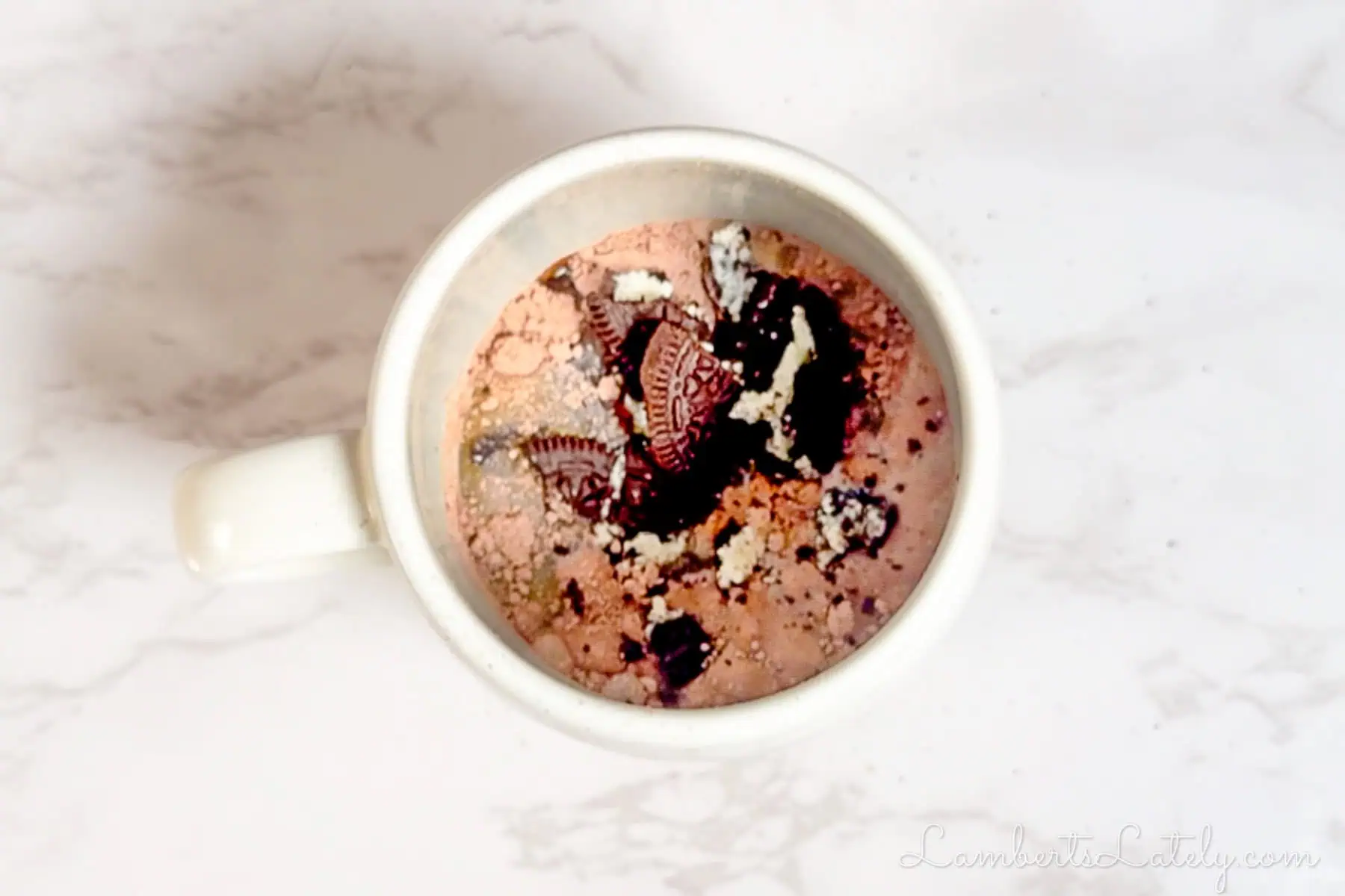 ingredients for oreo mug cake in a coffee cup.