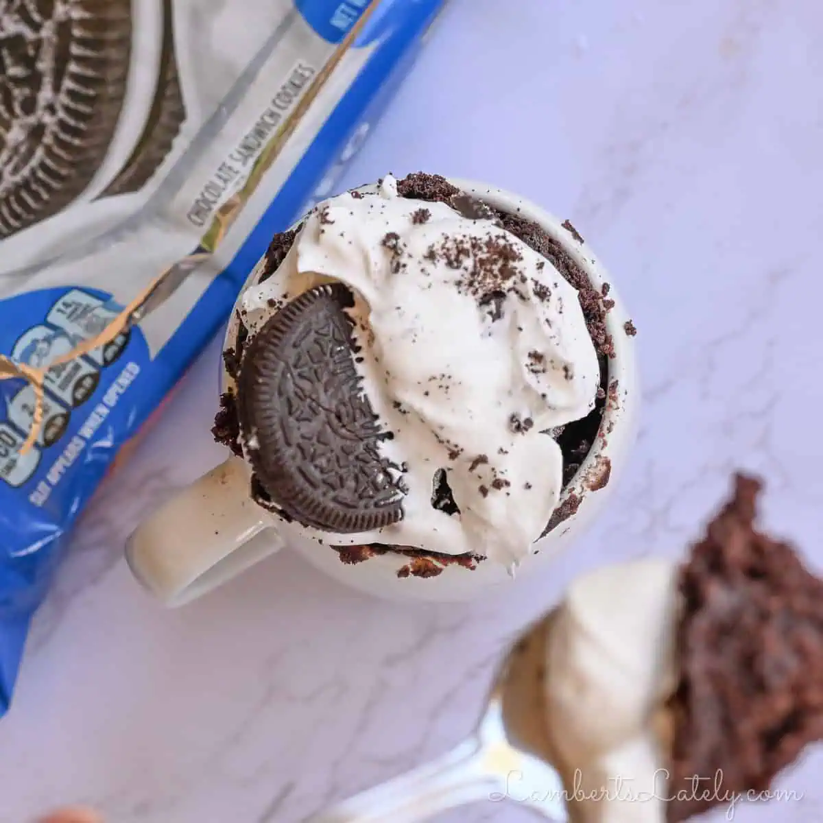 looking down at an oreo mug cake with a box of oreos.