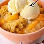 Delicious peach cobbler with vanilla ice cream in a pink bowl, topped with cake mix.