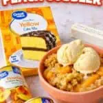 Crock Pot Peach Cobbler with cake mix and vanilla ice cream in a bowl.
