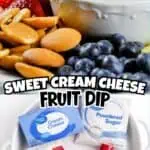 Sweet cream cheese fruit dip with strawberries blueberries and cookies.