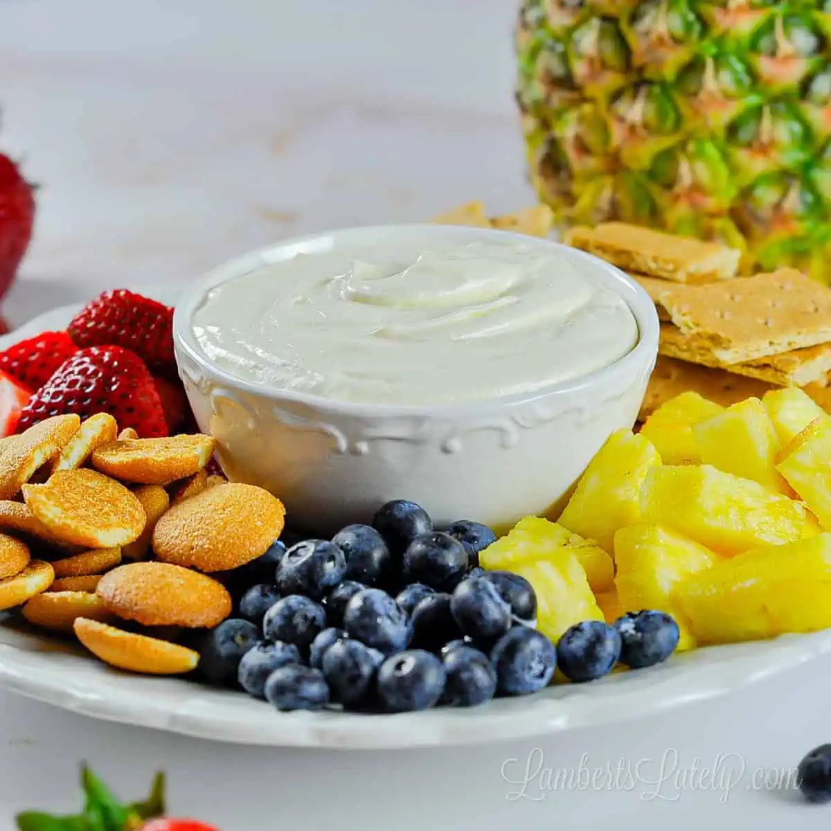 sweet cream cheese fruit dip with fruit and crackers.