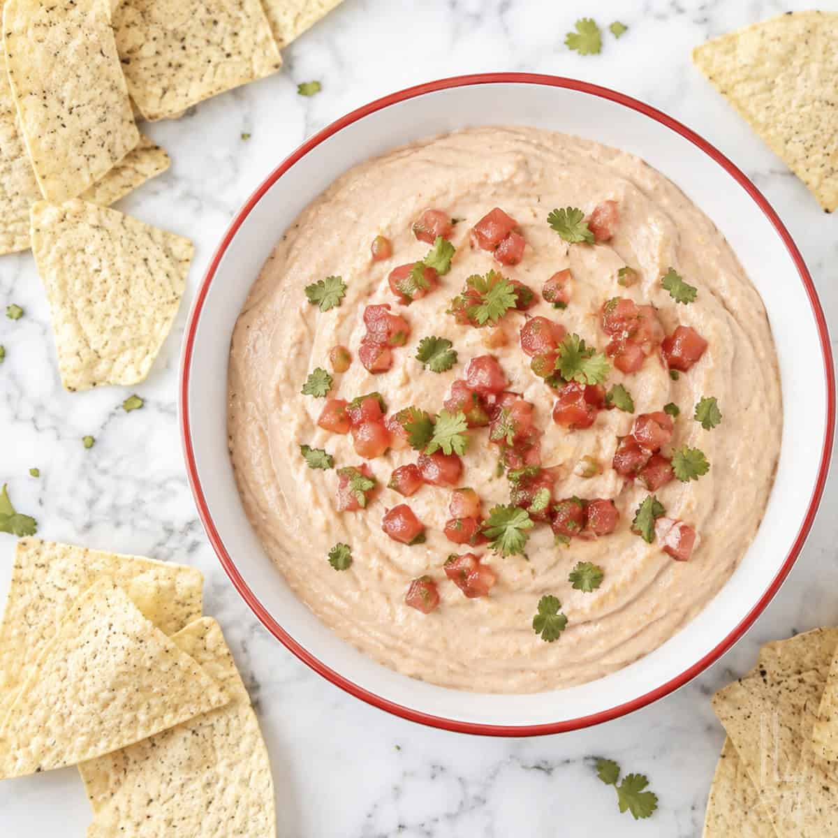 Cream cheese and salsa dip garnished with cilantro, served with tortilla chips.