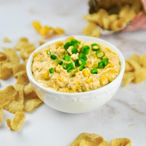 corn dip in a bowl, surrounded by chips.