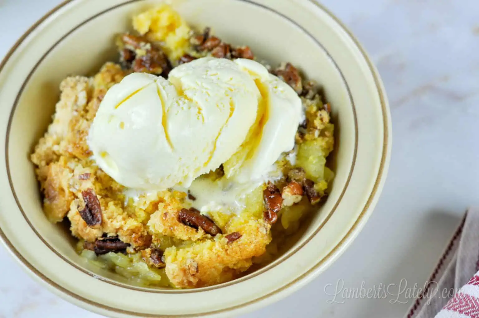 bowl of pineapple dump cake with ice cream.