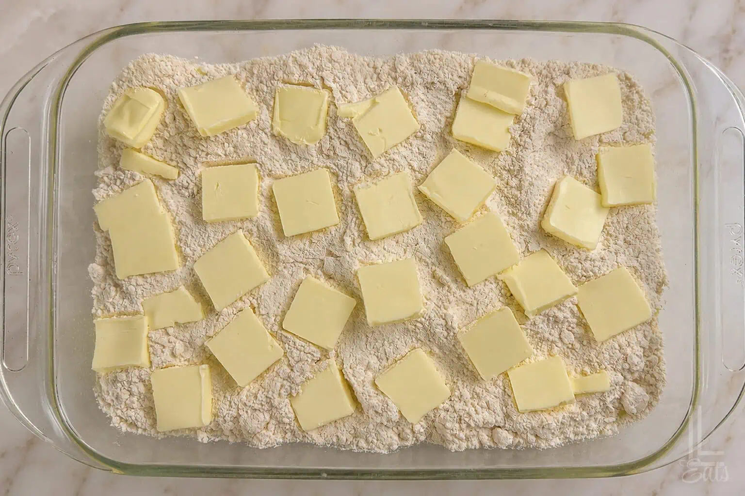 pats of butter on top of dry cake mix in a baking dish.