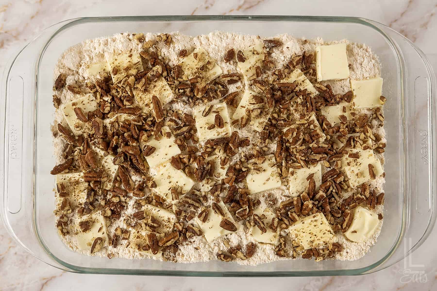 pecans on top of the butter pats in a glass dish.