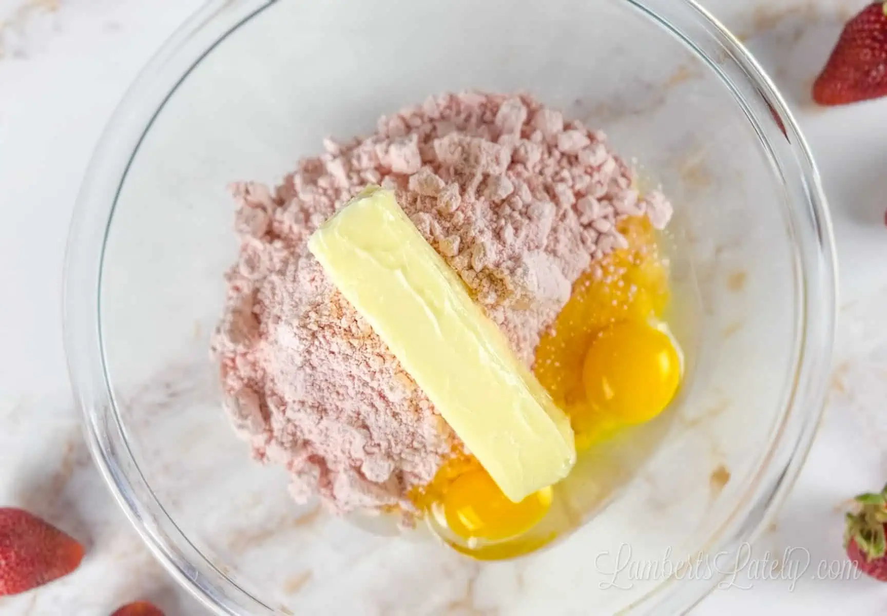 strawberry cake mix, butter, and eggs in bowl.