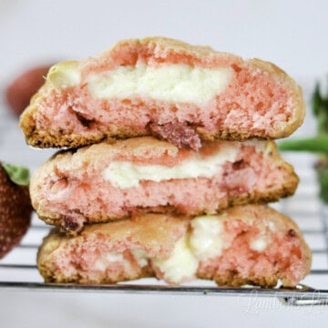three strawberry cheesecake cookies on a baking rack.