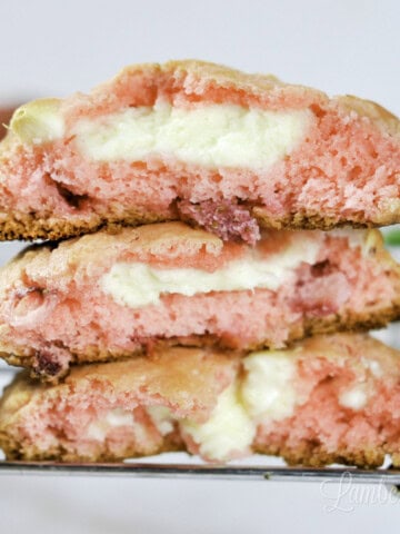 three strawberry cheesecake cookies on a baking rack.