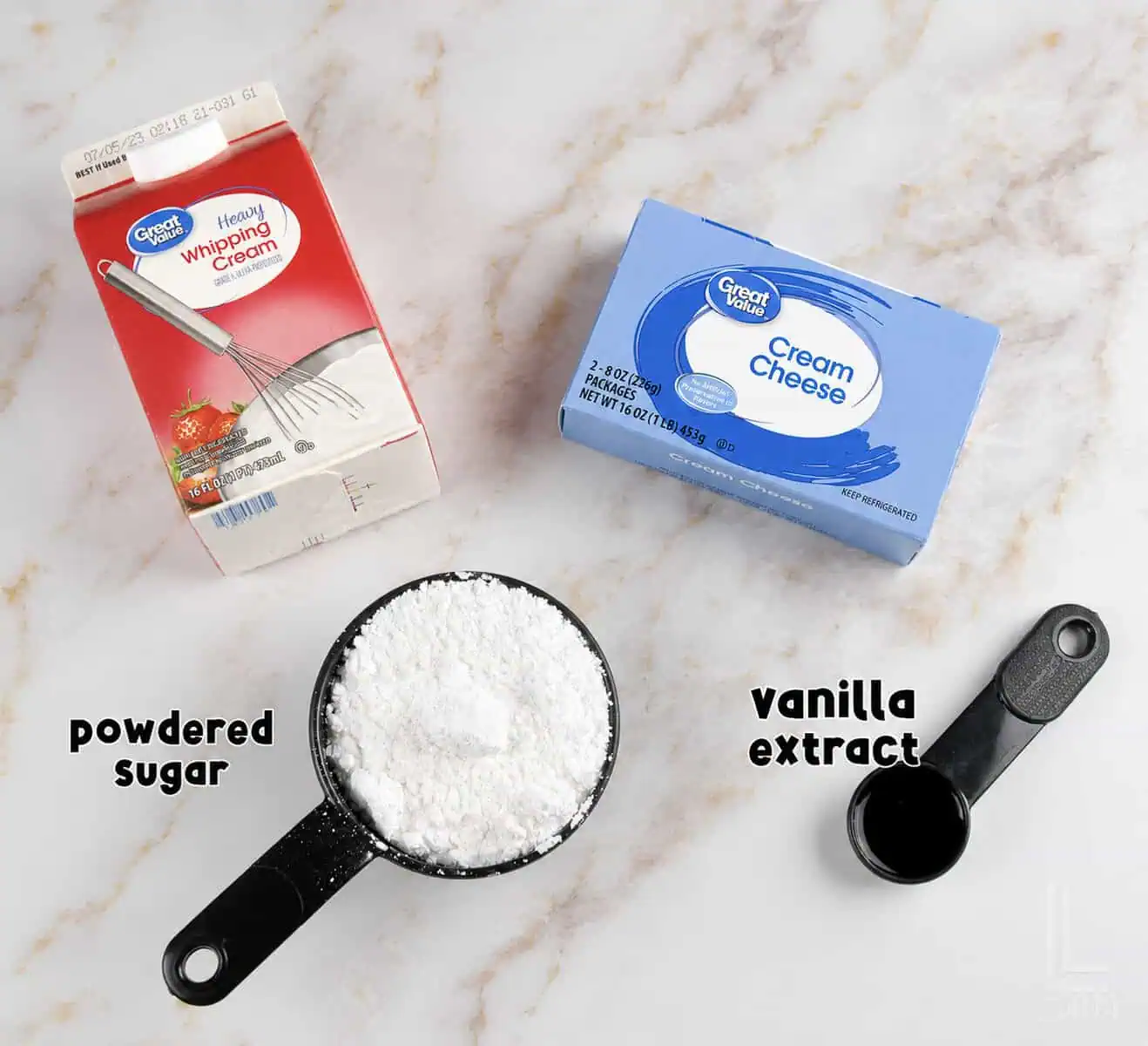Powdered sugar, heavy cream, cream cheese, and vanilla extract on a marble surface for sweet cream cheese fruit dip.