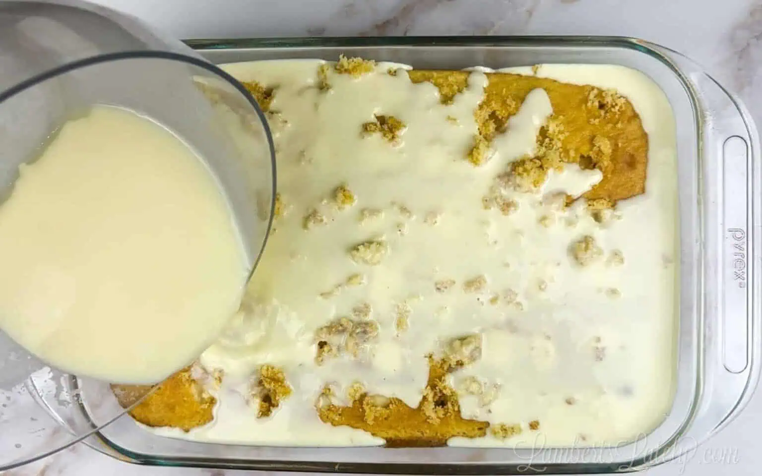 pouring pudding mix over a banana cake.