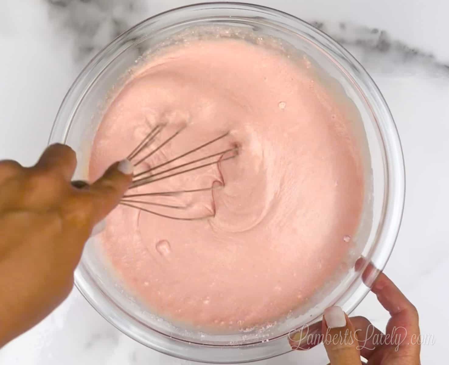 mixing pink cake mix pancake batter in a bowl.