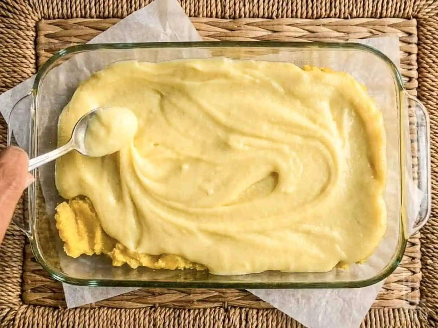 spreading the cream cheese layer of lemon chess bars with a spoon.