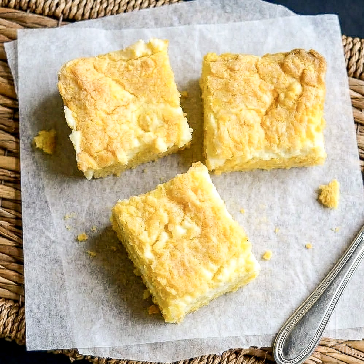 looking down on 3 lemon chess bars on parchment paper.