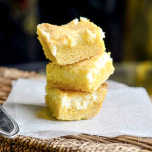 lemon chess bars stacked on parchment paper.
