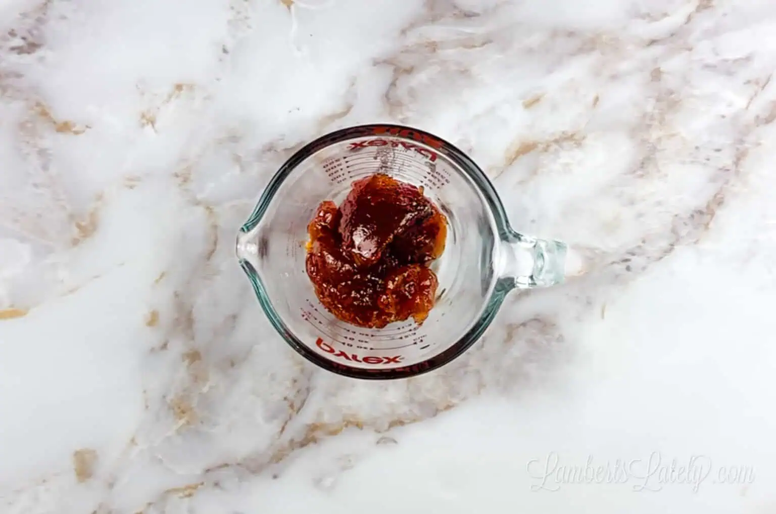 strawberry preserves in a measuring cup.
