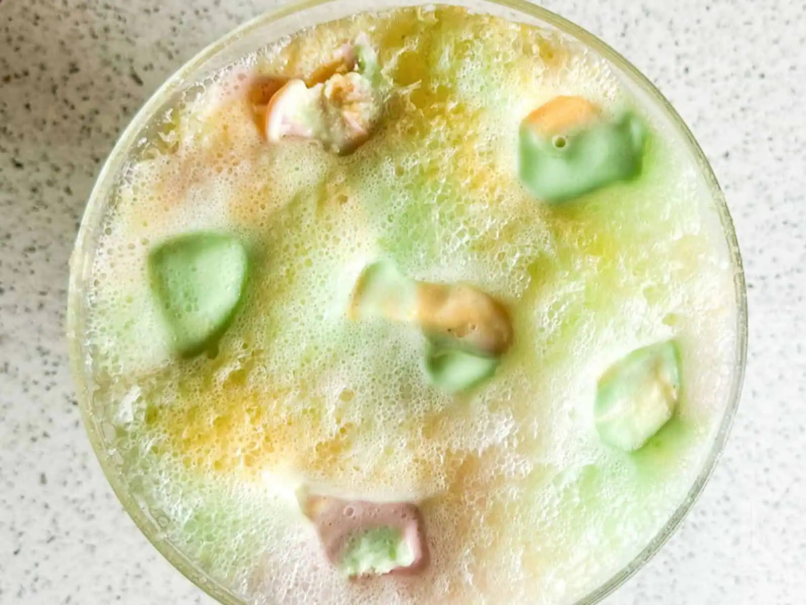 Large scoops of rainbow sherbet floating on top of a bubbly punch mixture.