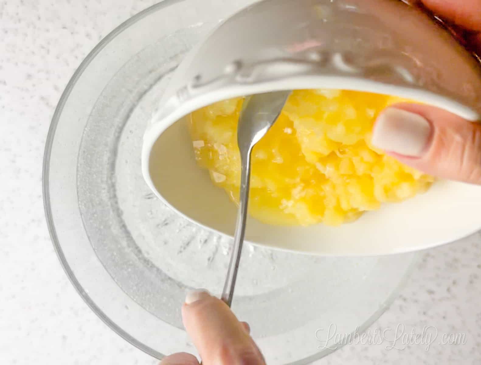 adding crushed pineapple to a punch bowl of lemon lime soda.