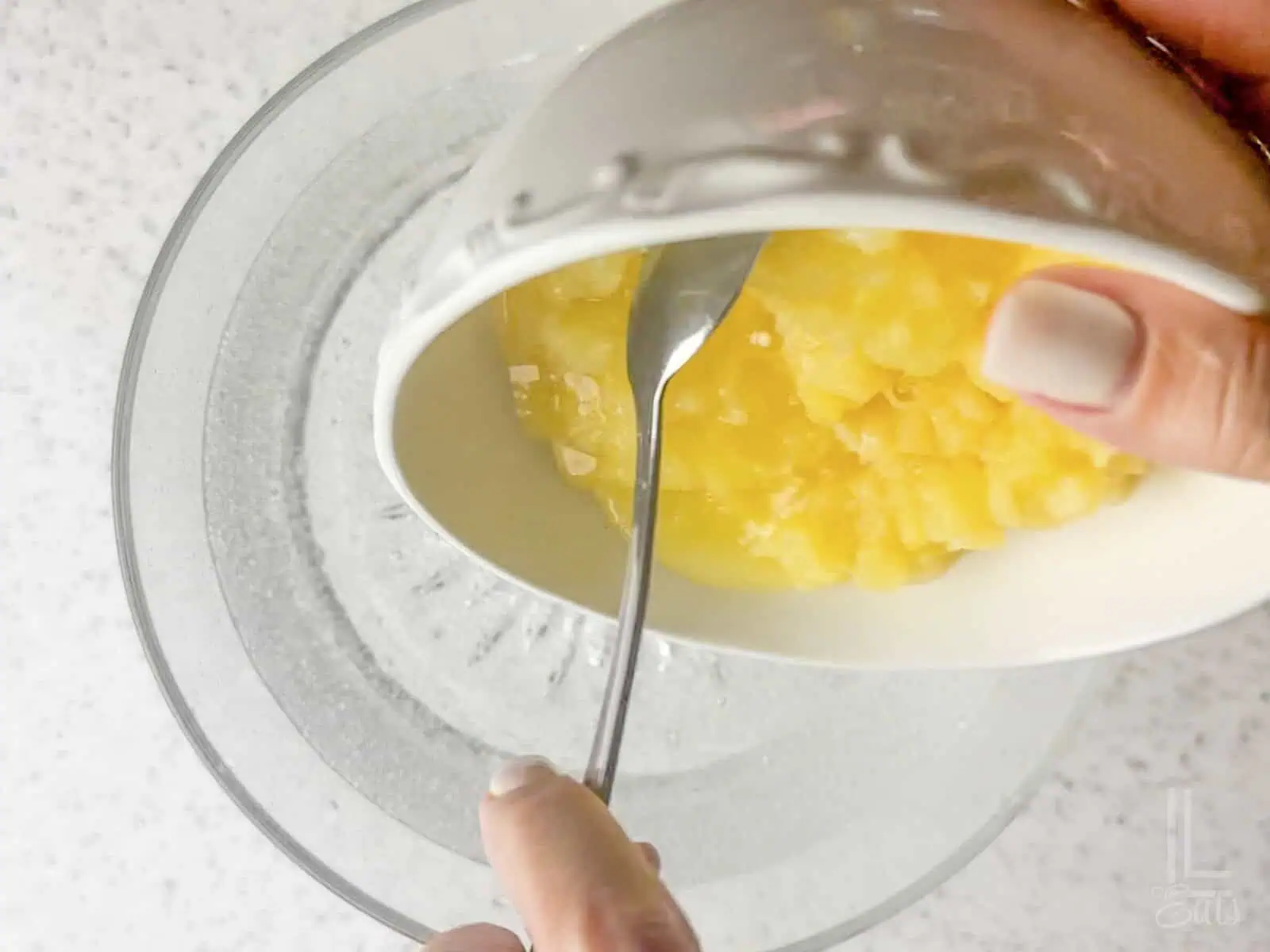 Pouring a bowl of canned crushed pineapple into the lemon-lime Sprite soda base.