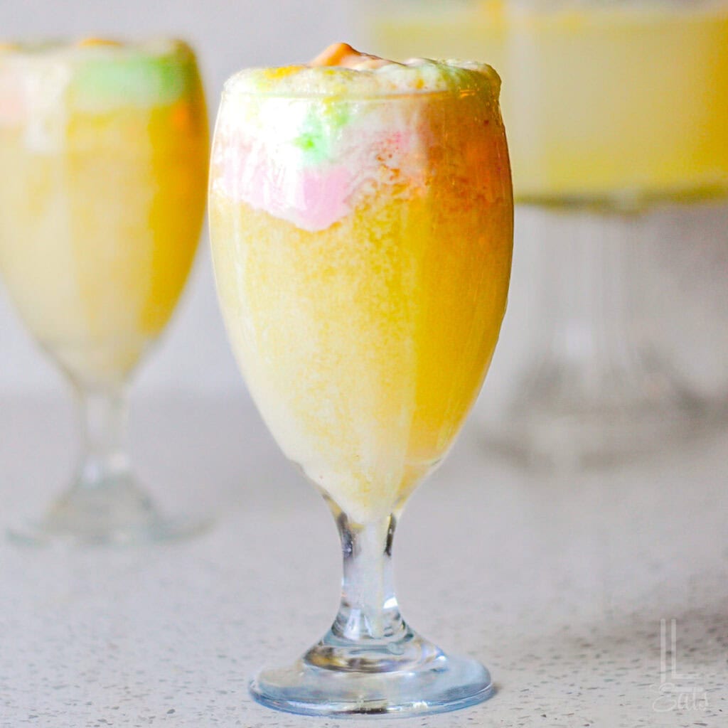 Creamy mango sorbet in a glass with a spoon, perfect for a healthy treat.