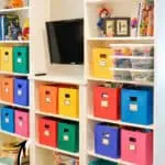 Colorful storage bins in a built-in Ikea Billy bookcase in a playroom.