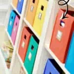 Colorful storage bins on a white shelf for small playroom organization.