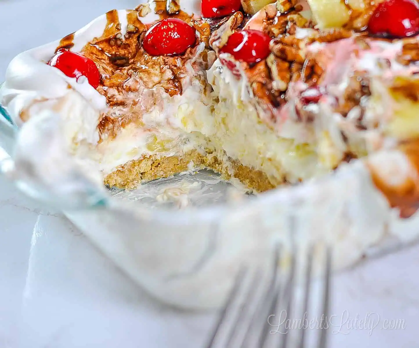 close up of cut out piece of banana split cake in a glass dish.