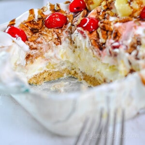 close up of cut out piece of banana split cake in a glass dish.