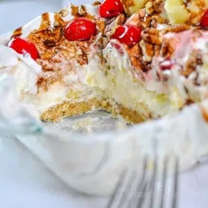 close up of cut out piece of banana split cake in a glass dish.