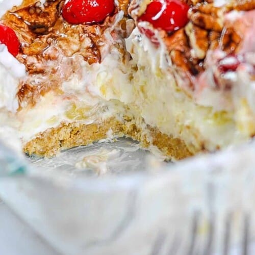 Looking into a banana split cake that's been cut, in a baking dish.