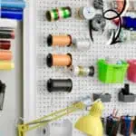 Organized craft room with pegboard and colorful spools of thread.