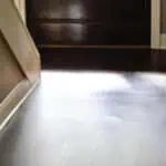 Clean vinyl plank flooring near a door with sunlight streaming in.