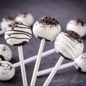 three oreo cake pops in front of a pile of cake pops in the background.