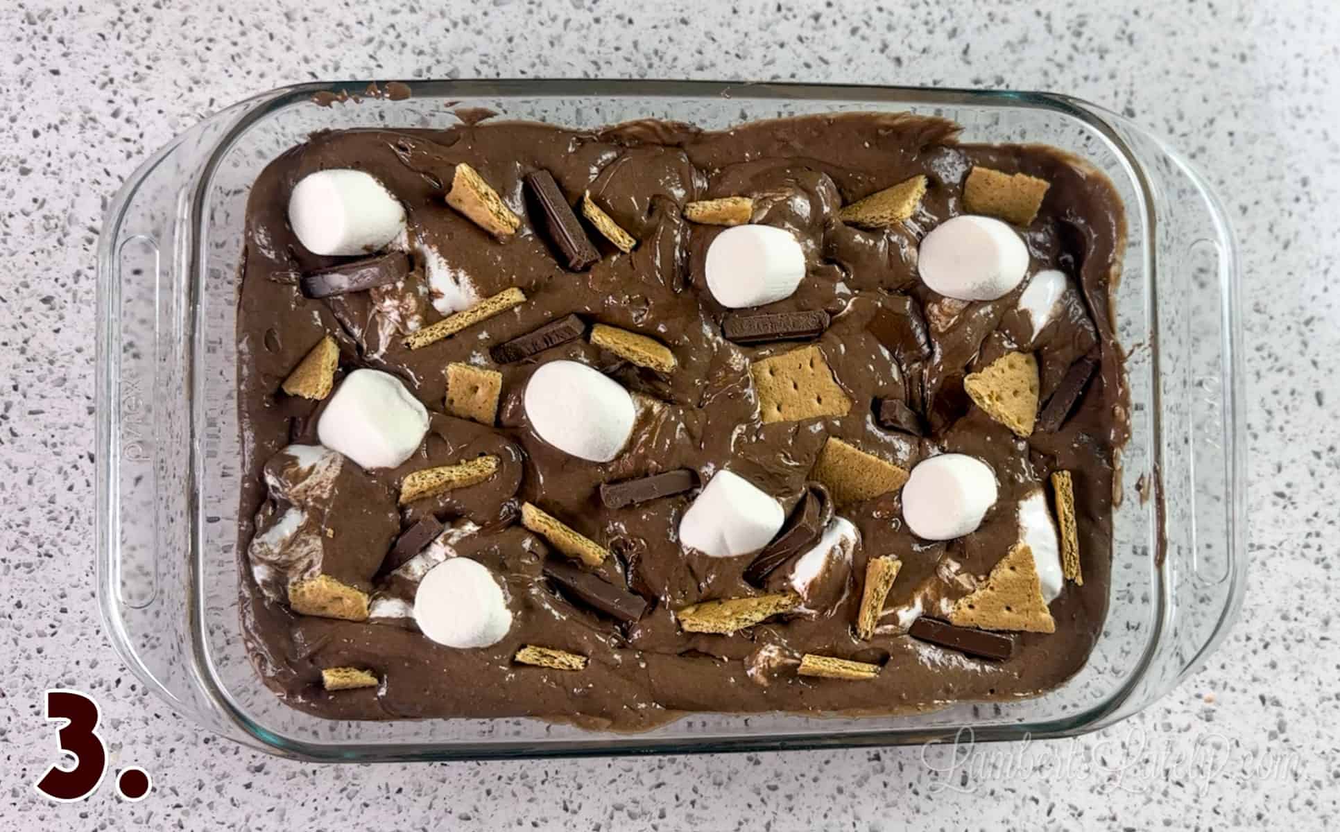 marshmallows, graham crackers, and chocolate bars pressed into cake batter mixture.