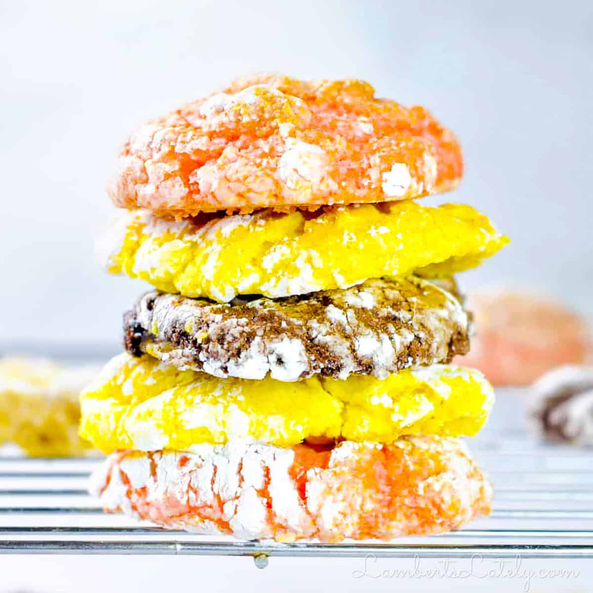 stacked cool whip cake mix cookies (lemon, chocolate, and strawberry) on a baking rack.
