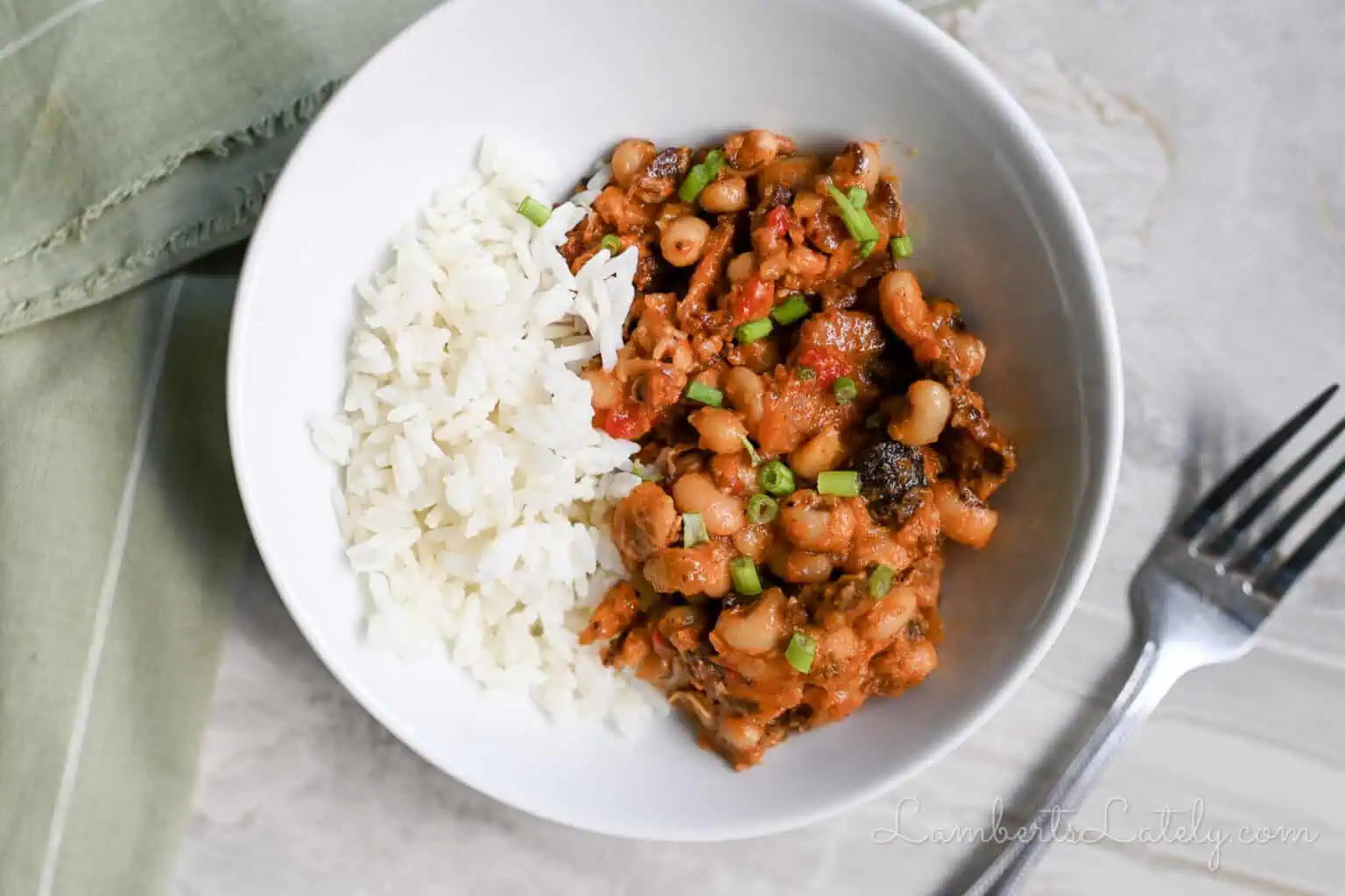 instant pot hoppin john in a bowl, next to a fork, napkin.