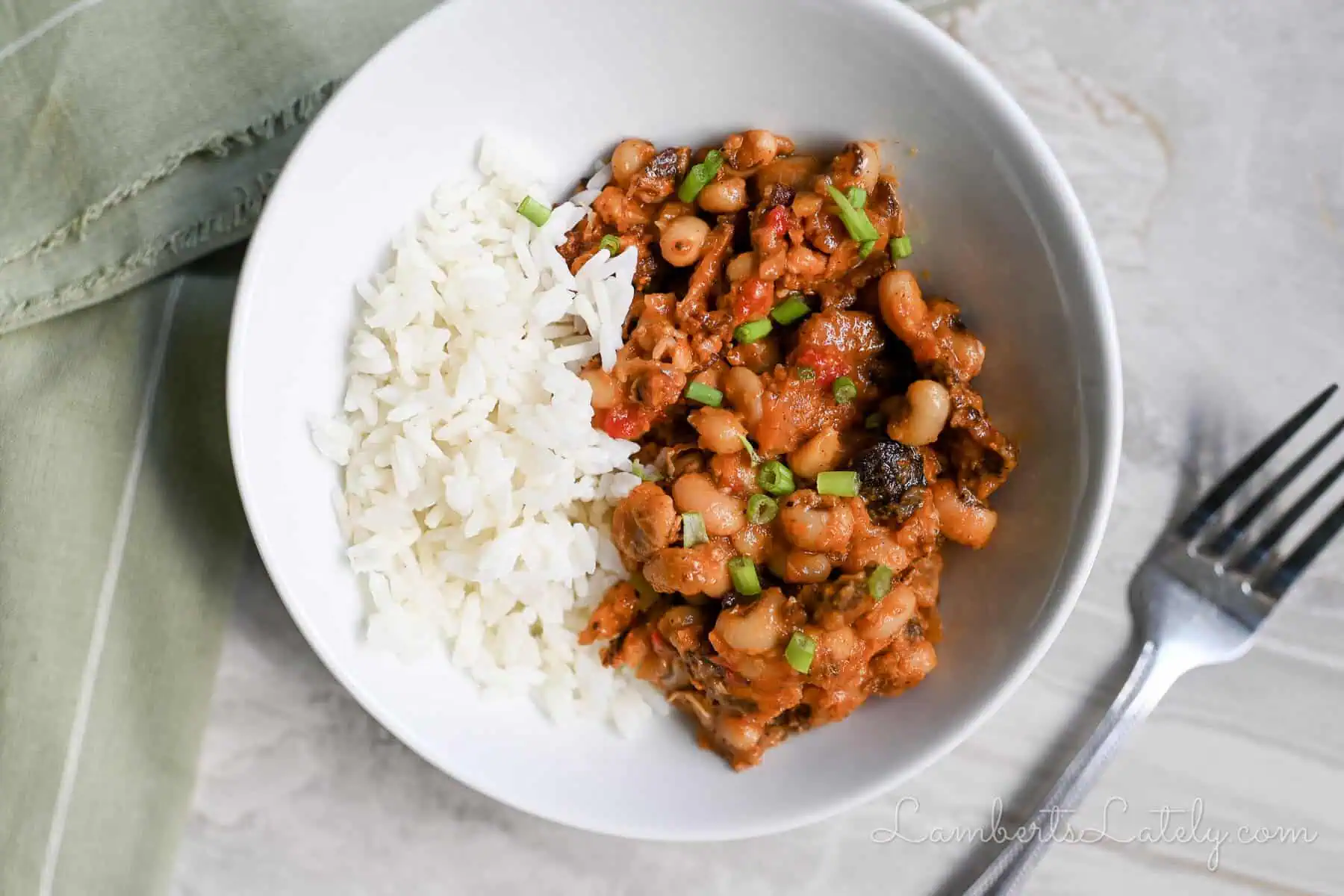 instant pot hoppin john in a bowl, next to a fork, napkin.