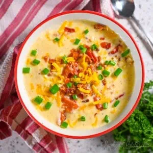 bowl of crockpot corn chowder topped with bacon, cheese, green onions.