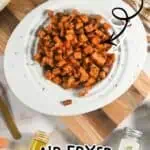 Crispy air fryer sweet potato cubes on a white plate with text overlay.