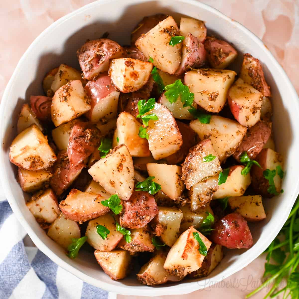 roasted red potatoes in a large bowl, garnished with parsley.
