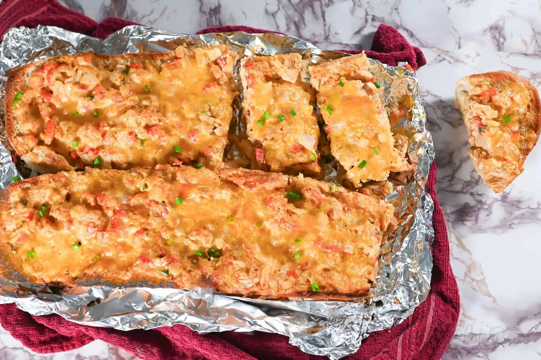 loaves of crawfish bread on aluminum foil.