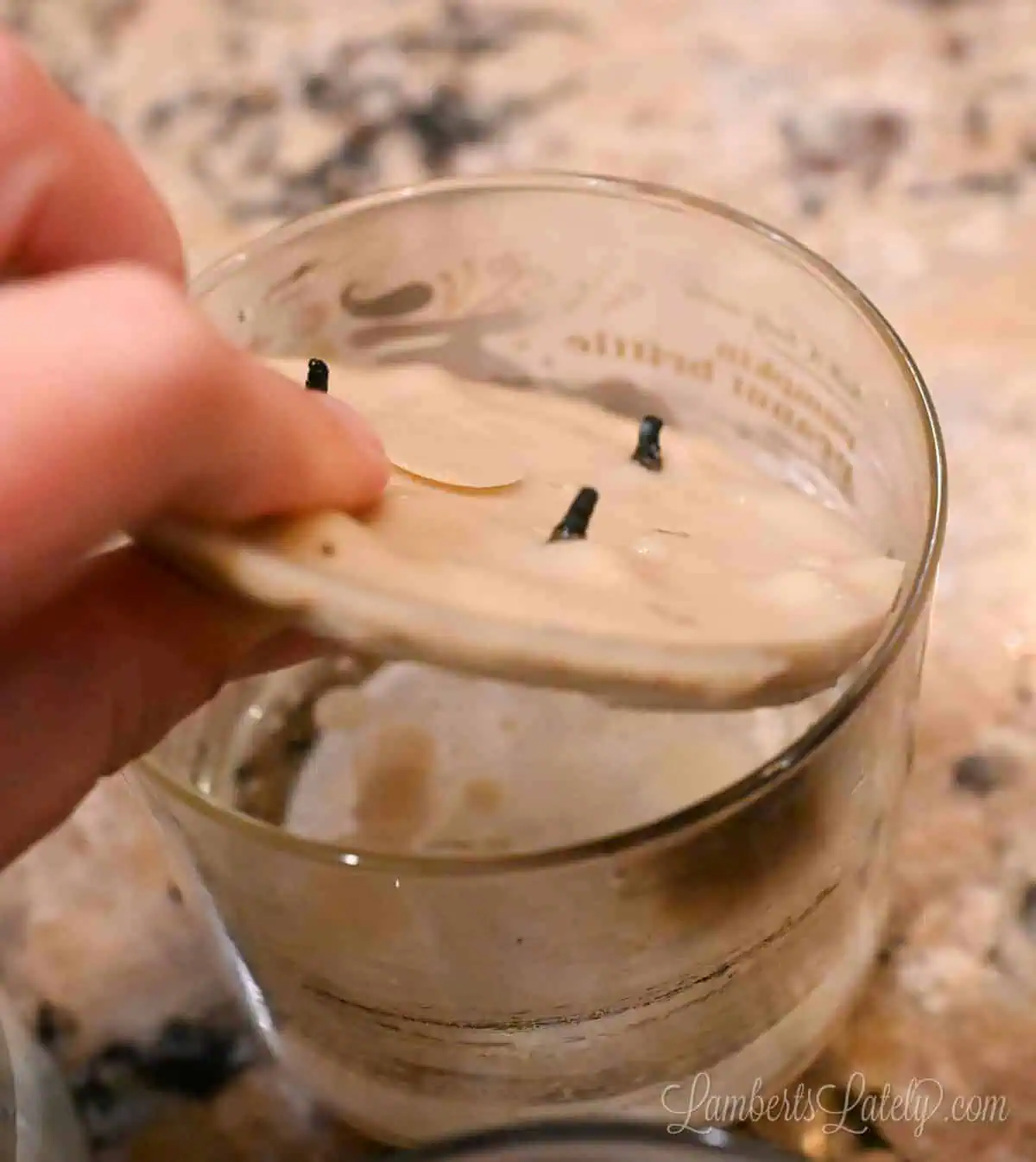 pulling dried wax out of a candle jar.