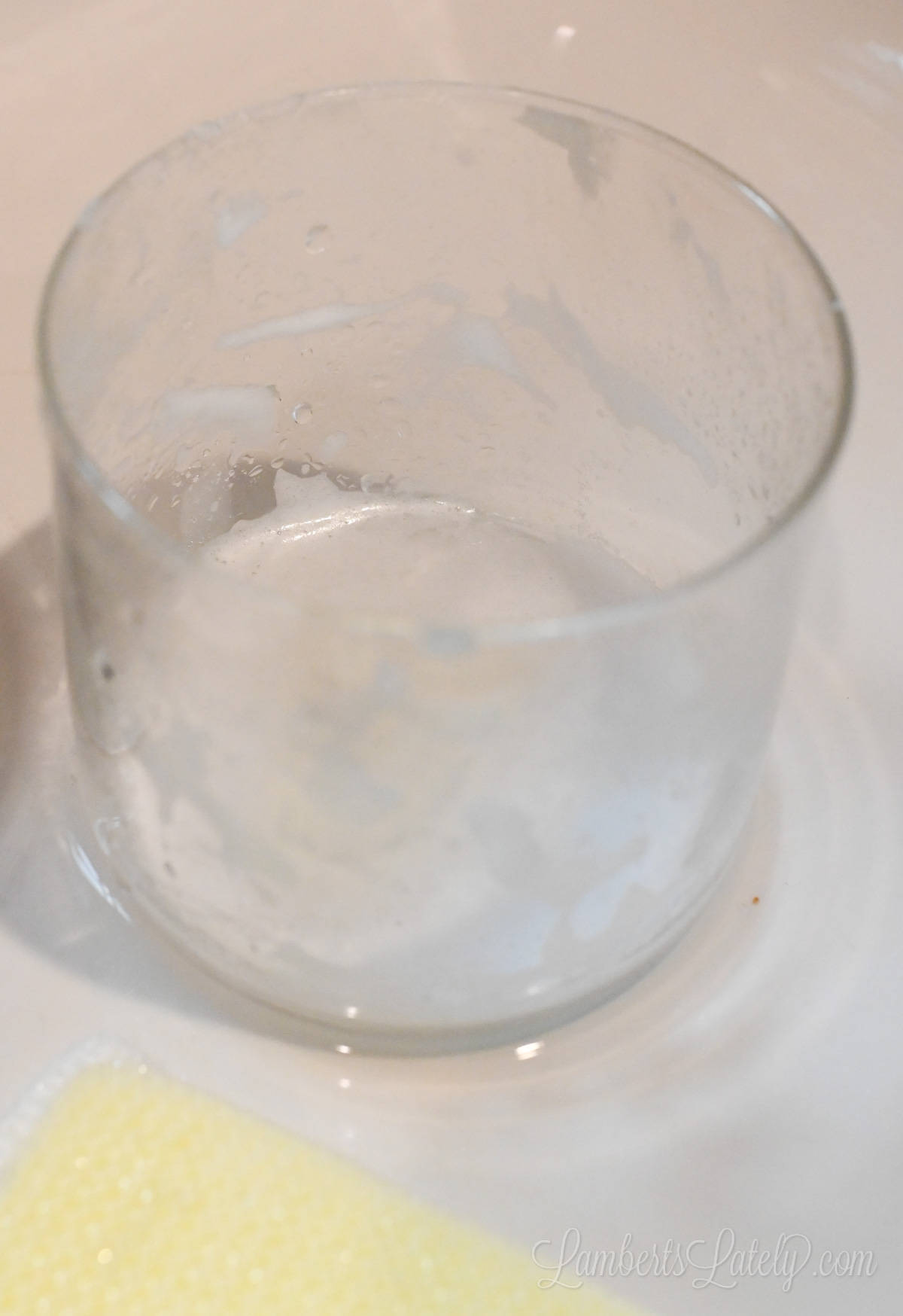 glass jar covered with soap in a sink.