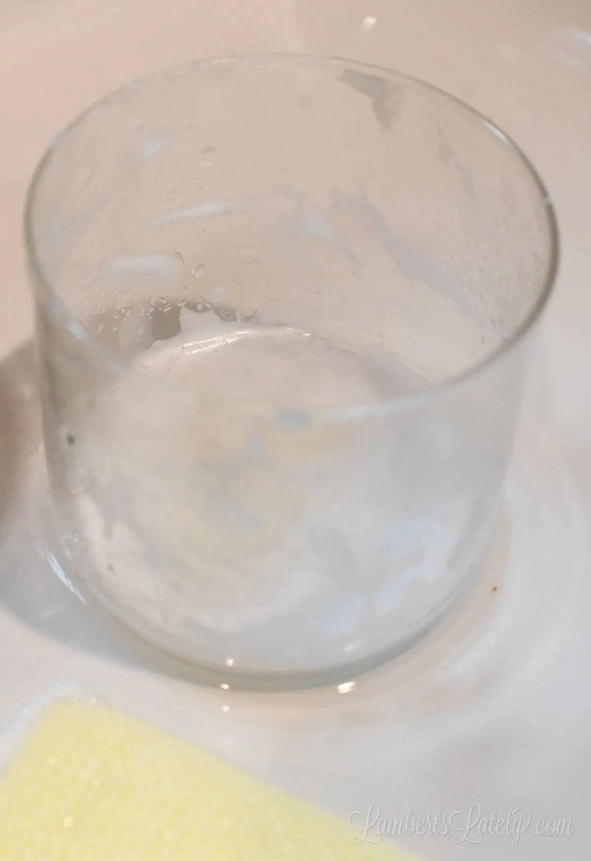glass jar covered with soap in a sink.