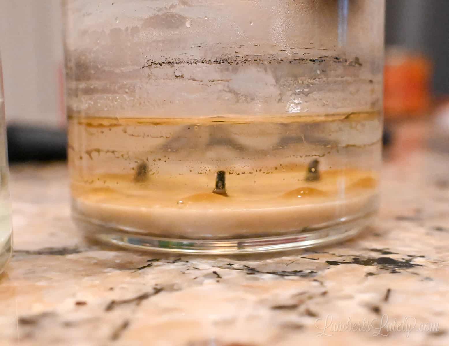 side view of a candle jar with hot water, melting the wax.