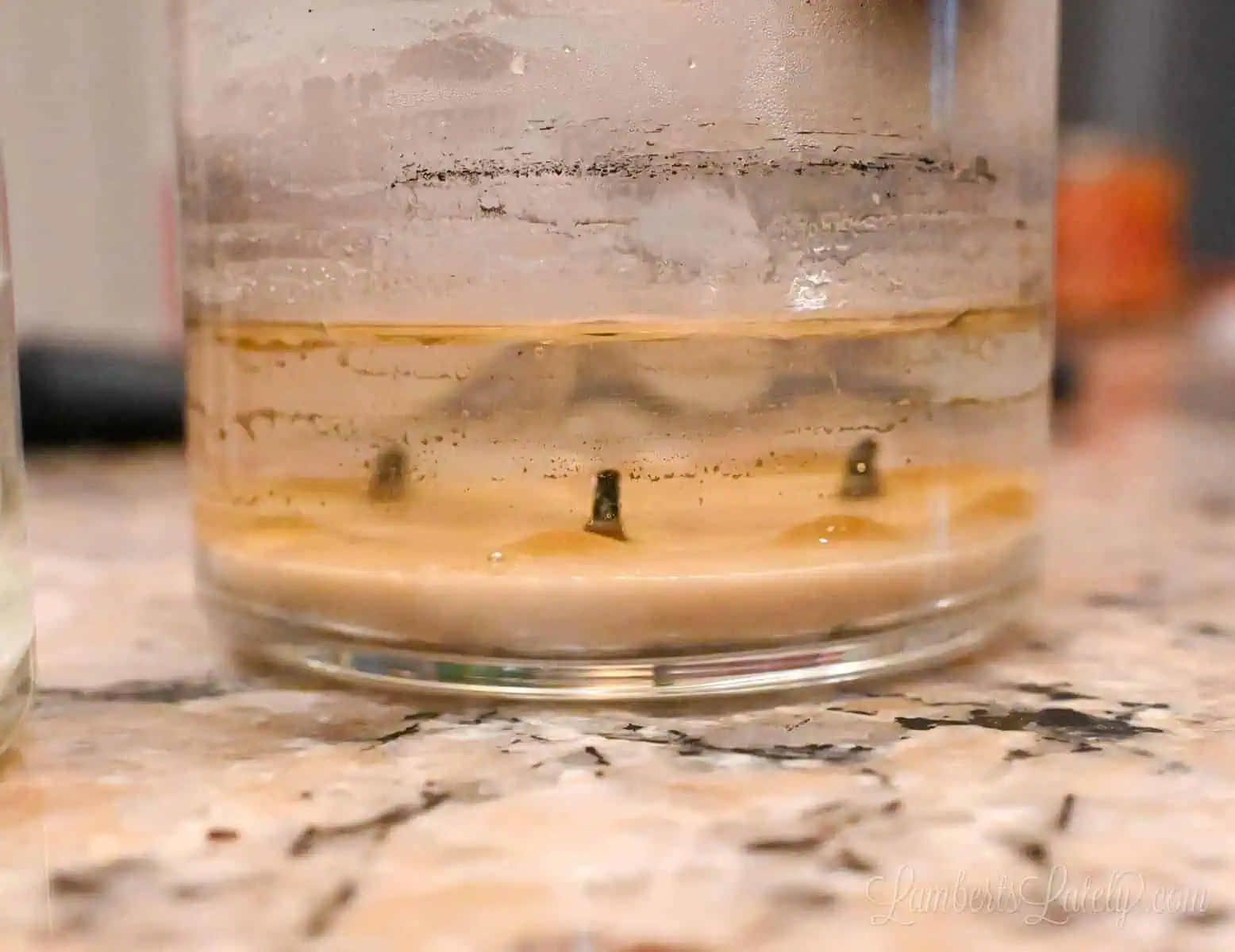 side view of a candle jar with hot water, melting the wax.